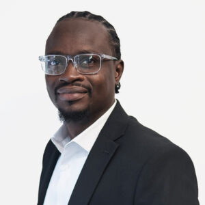 Adegoke Gbadamosi, Project Manager, with short dark brown hair and a goatee, smiling in a black jacket.