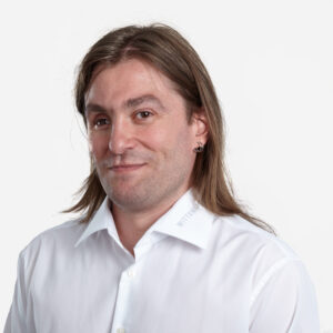 Emiliano Costagli, Product Manager, with long brown hair, smiling in a white shirt.